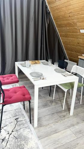 a white table with two chairs and a table with plates at Fantastic view - Chalet Karakol in Karakol
