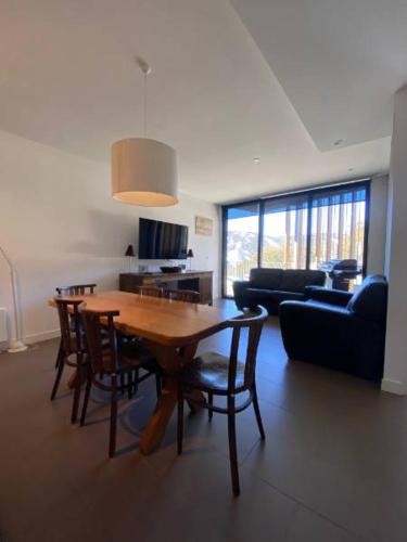 a living room with a wooden table and chairs at St Falls Apartment E509 in Falls Creek