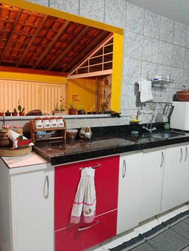 a kitchen with a red and white counter top at Casa Amarela-Quartos in Uberlândia