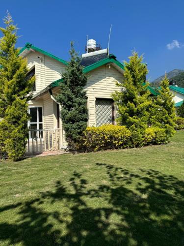 a house with trees in front of it at Karinya Villas in Nainital