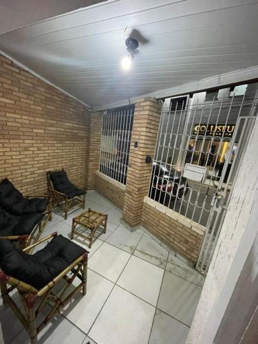 a balcony with chairs and a barred window at Casa Fátima in Aparecida