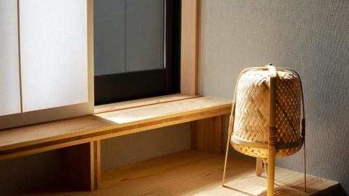 a chair sitting next to a desk with a television at 別府ホテル塒 Beppu Hotel Negura in Beppu