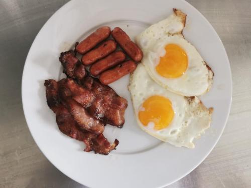贝勒沃格Berlevåg Motell AS的一盘有鸡蛋和培根的早餐食品