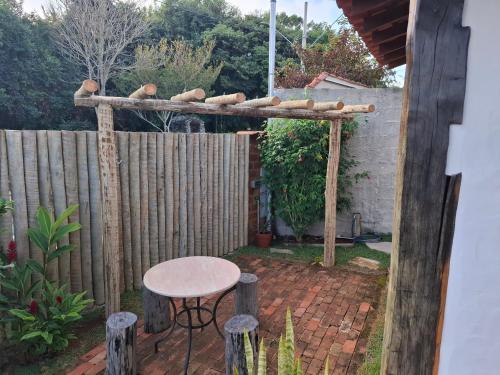 een achtertuin met een tafel en een houten hek bij Chalé Cores da Mata Inaugurado recente - novinho in Carrancas
