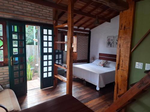 een slaapkamer met een bed in een kamer bij Chalé Cores da Mata Inaugurado recente - novinho in Carrancas