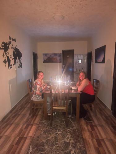 two women sitting at a dining room table at Ad Deir Guesthouse in Wadi Musa