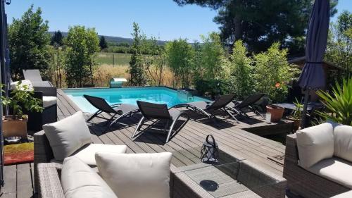 une terrasse avec des chaises et une piscine dans l'établissement Bastide avec jardin arboré, piscine, proche plages, à Cournonsec