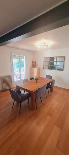 - un salon avec une grande table en bois et des chaises dans l'établissement Charmante maison de vacances, à Vallon-Pont-dʼArc
