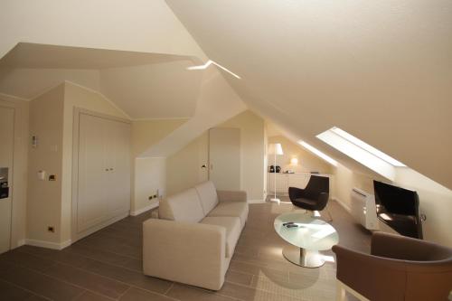 a living room with a white couch and a chair at Hotel Miramare & Spa in Sestri Levante
