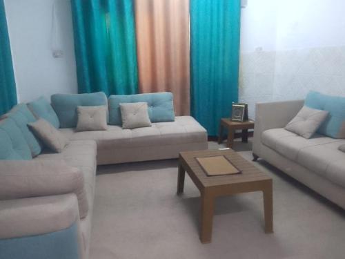a living room with two couches and a coffee table at الخير لشقق المفروشه in Al Jafr