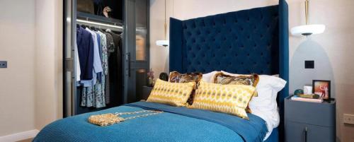 a bedroom with a blue bed with yellow pillows at Merino Gardens Deluxe 3 Bed by Tower Bridge in London