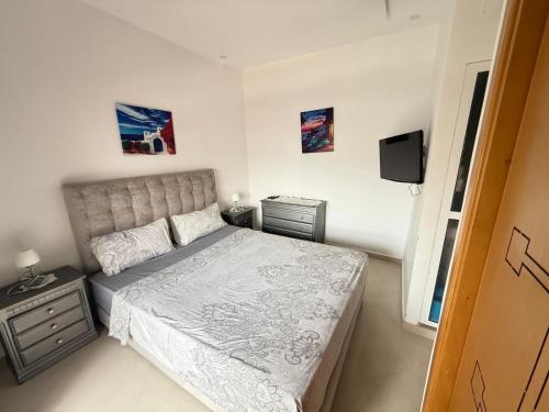 Un pequeño dormitorio con una cama y un televisor. en Bahia plage, en Tetuán