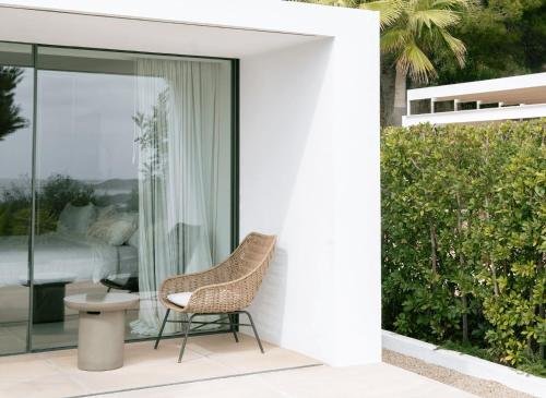 a wicker chair sitting on a patio next to a bedroom at Ander in Es Cubells
