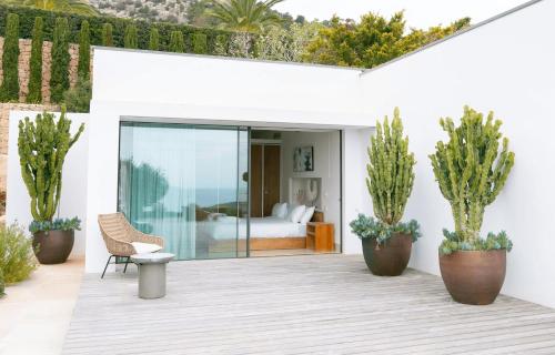 a patio with a bed and potted plants at Ander in Es Cubells