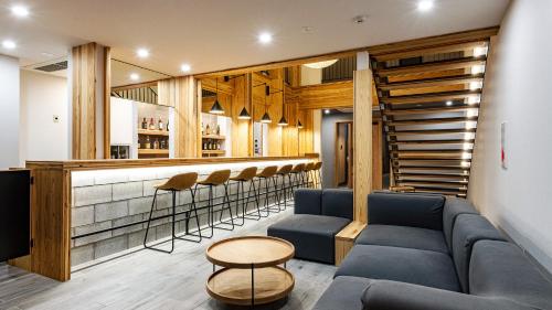 a bar with a blue couch and a bar with stools at 別府ホテル塒 Beppu Hotel Negura in Beppu