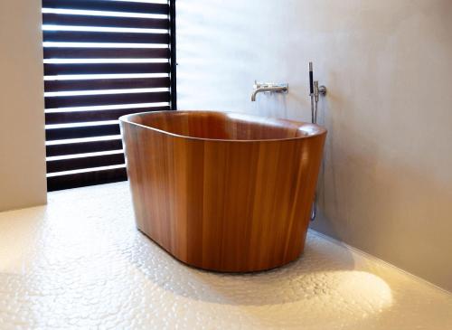 a wooden tub in a bathroom with a window at Ander in Es Cubells