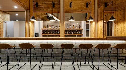 a bar with brown stools in a restaurant at 別府ホテル塒 Beppu Hotel Negura in Beppu