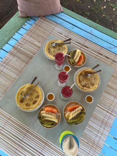 a table with many plates of food on it at Exotic house in Gili Meno