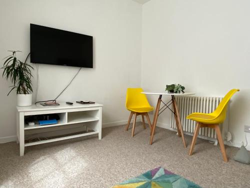 a living room with a tv and a table and chairs at Quay Apartment with parking in Aberdeen