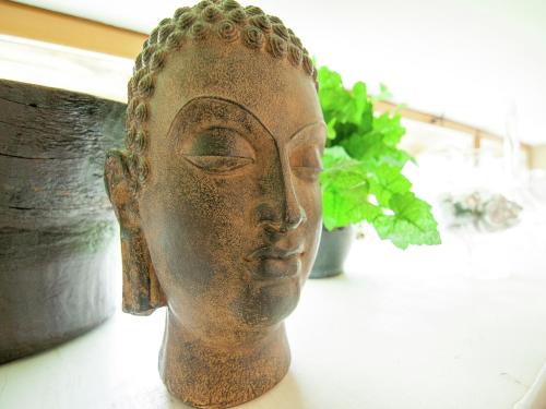 a statue of a head sitting on a table at Very nice cottage with studio on a domain with heated pool in Roussines