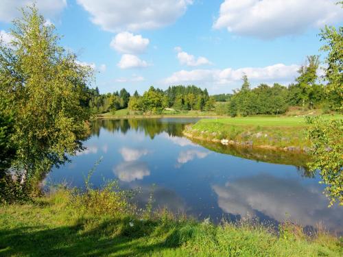 a view of a lake with trees and clouds at Very nice cottage with studio on a domain with heated pool in Roussines