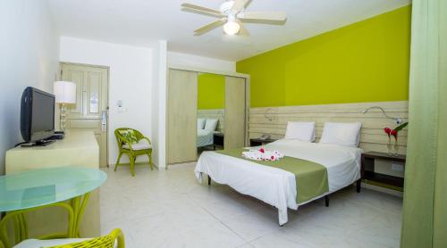 a bedroom with a bed with a green wall at Hotel Villa Taina in Cabarete