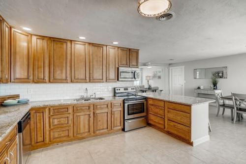 a kitchen with wooden cabinets and a stove top oven at Between the Waves Cottage by the Sea in Ormond Beach