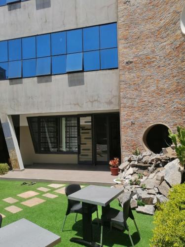 a table and chairs in front of a building at OLA LUXURY HOTEL Parakou in Parakou