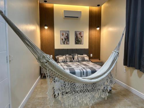 a bedroom with a hammock bed in a room at Casinha da Ana in Bacabal
