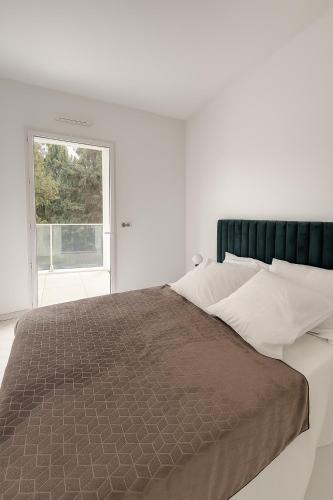 une chambre avec un grand lit avec une fenêtre dans l'établissement Appartement Neuf Marseille Plage, à Marseille