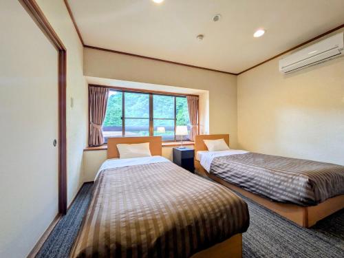 Postel nebo postele na pokoji v ubytování Itoen Hotel Shima