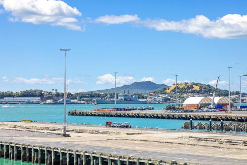 a marina with a pier and boats in the water at Waterfront Loft at Quay, Walk to Ferry & Train in Auckland