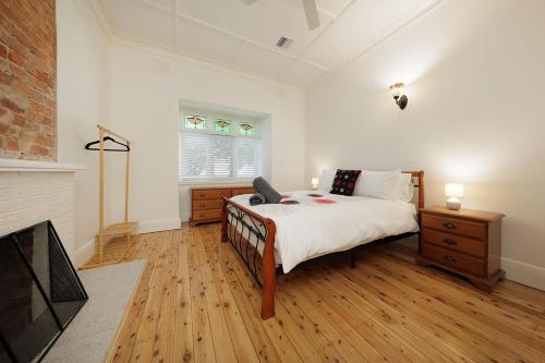 una camera con un grande letto e un camino di 'Braeside'- Victoria St's Secret ad Albury