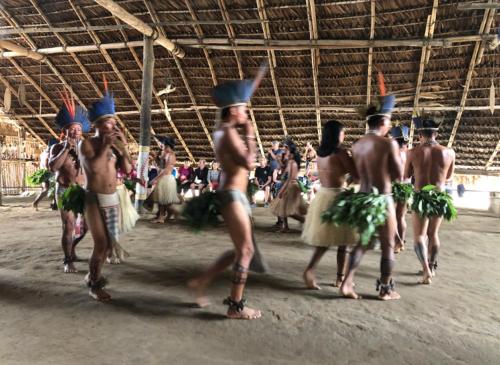 a group of men performing a dance in an arena at Curupira Amazon Lodge - Private Jungle Tour, River Tour or Great Adventure Tour Included in the Walking Safari Price in Iranduba