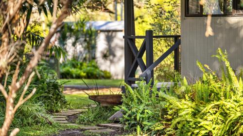 a garden with a fence and a stone path at Wooli River Lodges in Wooli