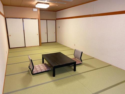 an empty room with a table and chairs in it at Itoen Hotel Shima in Nakanojo