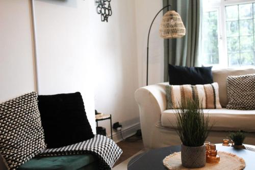 a living room with two chairs and a table at SHM Stays Solihull HS2 NEC Airport Nr M6 M40 M42 Great for Long & Short stays 15 min walk to Train Station 5 min drive to Town Centre outside Bus Stops & Supermarket Free Parking in Solihull