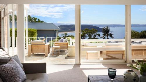 a living room with large glass windows and a view of the ocean at Viewpoint in Palm Beach