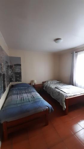 a bedroom with two beds and a window at Casa Torres in Curacautín