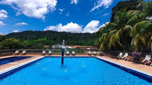 Una piscina con una fuente en la cima de un complejo turístico. en Tekoma Resort Taman Negara, en Kuala Tahan