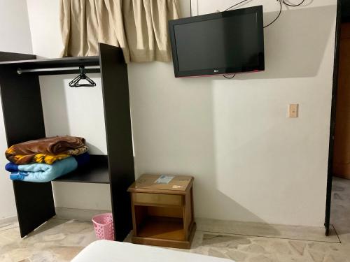 Una televisión o centro de entretenimiento en HOTEL EJECUTIVO PITALITo