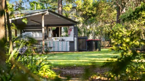 a small house in a yard with a garbage can at Wooli River Lodges in Wooli