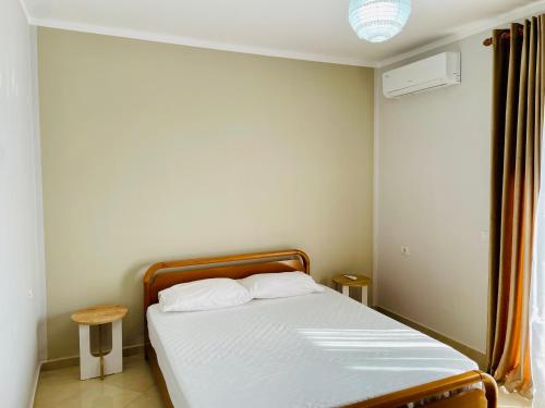 a bedroom with a bed with white sheets at EasyTrip Family - City Center in Divjakë