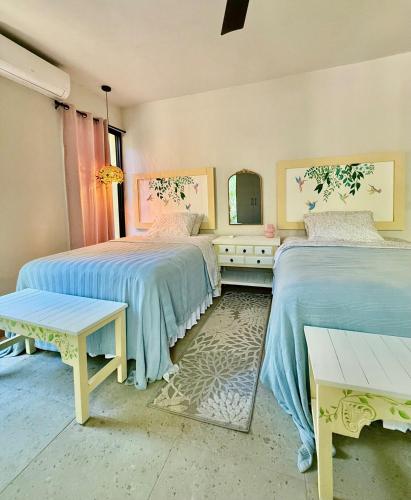 een slaapkamer met twee bedden en een spiegel bij La Cueva De Piedra in Puerto Morelos