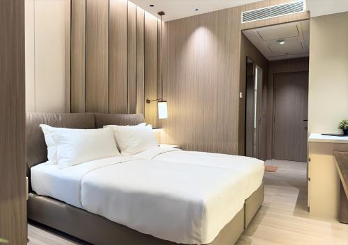 a bedroom with a large white bed in it at Somerset Queen City Semarang in Stasiun Tawang