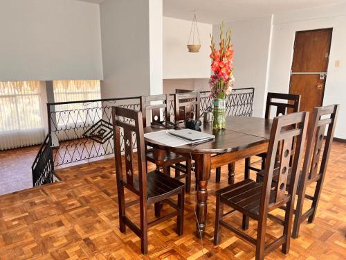 une table à manger avec des chaises et un vase de fleurs dans l'établissement 歇脚休息, à La Playa Bejarano