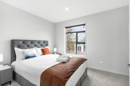 a bedroom with a large bed and a window at Sweet home near airport in Christchurch