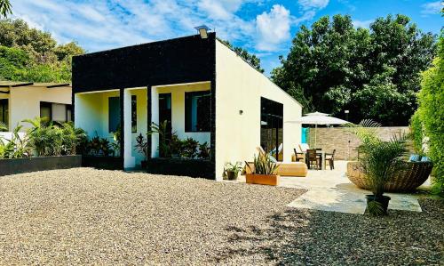 a house with a black roof and a patio at Villa Paz CASA QUINTA CON PISCINA PRIVADA in Ricaurte