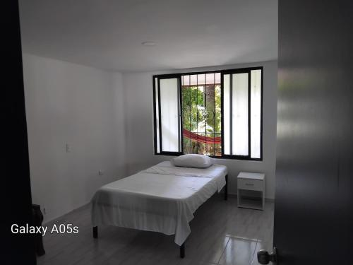 a white bedroom with a bed and a window at Villa kari in Palestina