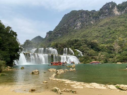 a group of people in the water in front of a waterfall at PIA homestay - Tours & Motorbike rentals - Cao Bằng in Cao Bằng
